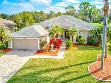 Beautifully landscaped home featuring a meticulously maintained lawn, colorful flowerbeds, and decorative fountain at 2439 Teton Stone Run, Orlando, FL 32828