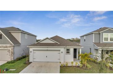 Charming single-story home featuring a gray exterior, attached garage, and manicured front yard at 4057 Sagefield Dr, Harmony, FL 34773