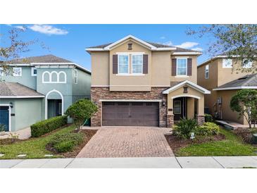 Charming two-story home with a brick driveway, attached two-car garage, and lovely landscaping at 431 Novi Path, Kissimmee, FL 34747