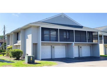 Condo exterior with garages and a second-story screened in balcony at 4448 Pinebark Ave # 56-1, Orlando, FL 32811