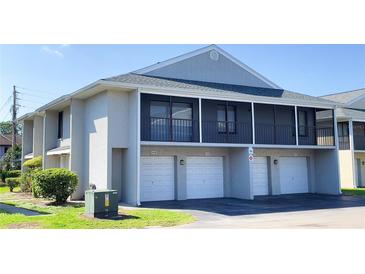 A view of the exterior of the townhomes with white doors, and a black balcony with metal railings above at 4448 Pinebark Ave # 56-1, Orlando, FL 32811