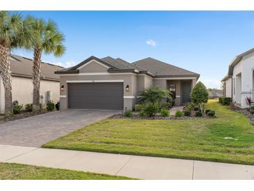 Charming single-story home with a two-car garage, well-maintained lawn, and mature landscaping at 938 Braewood Dr, Clermont, FL 34715