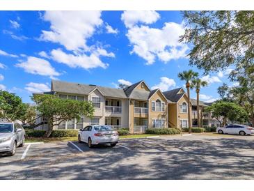 Apartment building exterior featuring multiple units, balconies, and ample parking spaces at 1015 S Hiawassee Rd # 3514, Orlando, FL 32835