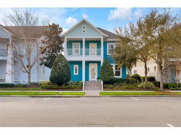 Inviting two-story blue home with a charming balcony and well-manicured landscaping at 13838 Walcott Ave, Orlando, FL 32827