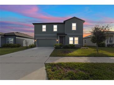 Charming two-story home with a well-maintained lawn and beautiful sunset sky at 1629 Hill Park Dr, Deltona, FL 32725