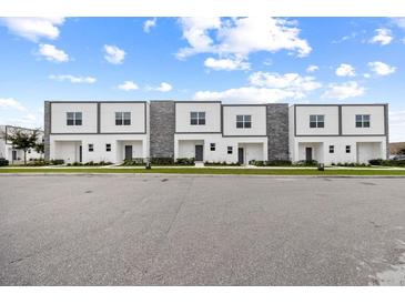 Modern townhomes feature a clean design with stone accents and a well-maintained green space at 205 Famagusta Dr, Davenport, FL 33896