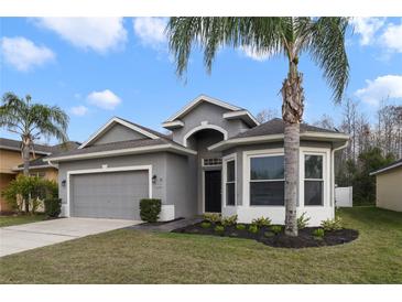 Charming single-story home with a well-manicured lawn and mature landscaping at 2502 Cypress Trace Cir, Orlando, FL 32825