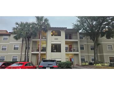 Three-story condo building with balconies, palm trees, and convenient parking at 3028 Parkway Blvd # 305, Kissimmee, FL 34747