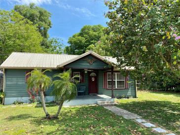 Charming home featuring a quaint front porch and a well-manicured lawn with mature landscaping at 435 Pleasant St, Lake Helen, FL 32744