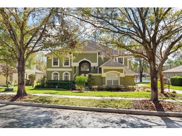 Two-story home with a beautifully landscaped yard and mature trees at 490 Wekiva Preserve Dr, Apopka, FL 32712