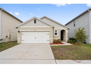 Charming single-story home featuring a two-car garage and tidy landscaping at 6745 Huntleigh Hammock Rd, Harmony, FL 34773