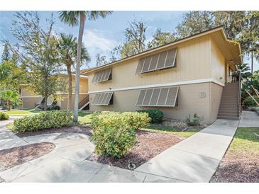 Inviting condo with lush landscaping, walkways, and stairs to the second level at 120 Hibiscus Woods Ct # 13B, Deltona, FL 32725