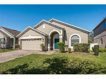 Charming single-story home featuring a well-manicured lawn and attached two-car garage at 15341 Urbino Ln, Orlando, FL 32828