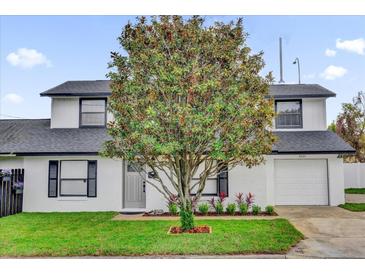 Charming two-story home featuring a well-manicured lawn and beautiful mature tree in the front yard at 2923 Cornell Ave, Orlando, FL 32804