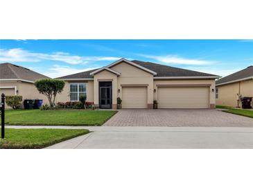 Inviting single-story home with a well-manicured lawn and two-car garage at 3504 Cayugas Loop, St Cloud, FL 34772