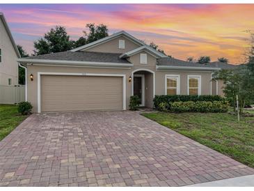 Charming single-story home featuring a brick driveway and well-maintained landscaping at 515 Darshire Ave, Eustis, FL 32736