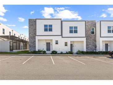 Modern townhome featuring neutral colors and a well-manicured lawn at 625 Trikomo Dr, Davenport, FL 33896