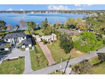 Stunning aerial view of lakefront homes with lush landscaping and private docks on a sunny day at 85 Interlaken Rd, Orlando, FL 32804