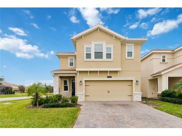 Inviting two-story home featuring a well-manicured lawn and a spacious two-car garage at 1100 Downswing Pl, Davenport, FL 33896