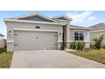 Beautiful home boasting a two-car garage and tidy landscaping at 1443 Lassen St, Haines City, FL 33844