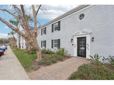 Charming two-story condo featuring well-maintained landscaping and a classic brick walkway leading to the front door at 224 Lewfield Cir, Winter Park, FL 32792
