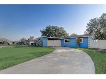 Charming blue single-story home with a well-manicured lawn and a concrete driveway at 2743 Grandola Dr, Orlando, FL 32811
