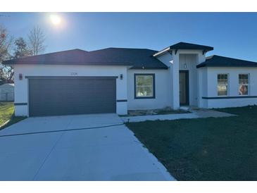 Charming single-story home with a two-car garage and a well-manicured front yard at 3324 Sw 137Th Loop, Ocala, FL 34473