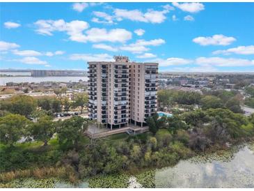 High-rise condo building with multiple balconies and a swimming pool surrounded by lush greenery at 7550 Hinson St # 11C, Orlando, FL 32819