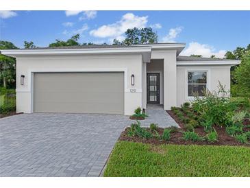 Beautiful one-story home with a gray garage door, gray brick paver driveway, and inviting landscaped front yard at 1251 Cresswind Blvd, Deland, FL 32724