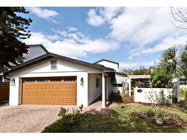 Charming single-Gathering home featuring a light-colored exterior, wood-look garage door, and well-manicured landscaping at 1611 Chestnut Ave, Winter Park, FL 32789
