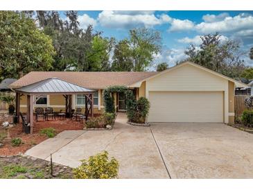 Charming single-story home with a two-car garage, complemented by a lovely pergola-covered seating area and manicured front yard at 22 Sweetwater Creek Cir, Oviedo, FL 32765