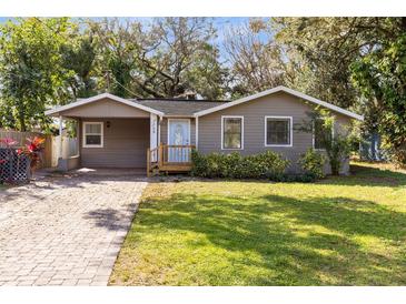 Charming one-story home with a landscaped front yard and a brick-paved driveway at 2208 Page Ave, Orlando, FL 32806