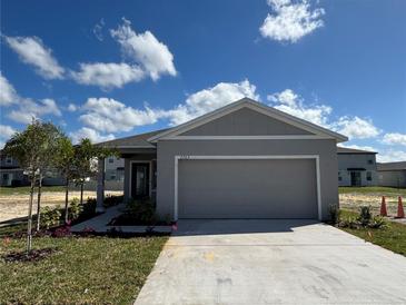 Charming single-story home with a gray exterior, a two-car garage and freshly planted front yard landscaping at 2763 San Marco Way, Winter Haven, FL 33884