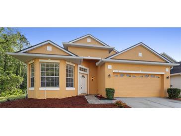 Beautiful exterior view of the home with a well-manicured lawn and a two-car garage with a neutral color scheme at 5509 Florence Harbor Dr, Orlando, FL 32829