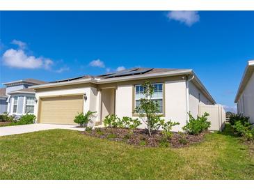 Inviting single-story home showcasing neutral stucco, solar panels, a two-car garage and manicured landscaping at 5637 Cedar Chase Dr, St Cloud, FL 34771