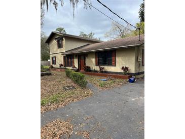 Charming home exterior with mature landscaping, flowerbeds, and a driveway at 612 Wolf Run, Winter Haven, FL 33880