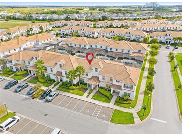 A beautiful aerial view showcases a condo building with a tile roof, parking, and manicured landscaping at 1569 Plunker Dr, Davenport, FL 33896