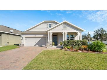 Charming single Gathering home boasts beautiful landscaping, brick paver driveway, and two-car garage at 1619 Leatherback Ln, St Cloud, FL 34771