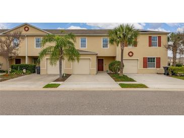 Inviting townhome featuring a 1-car garage, desert landscaping and a charming exterior design at 209 Arbor Lakes Dr, Davenport, FL 33896