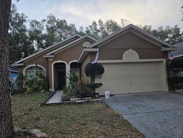 Charming single-Gathering home featuring a well-maintained lawn, two-car garage, and neutral color palette at 2119 Kaylas Ct, Orlando, FL 32817