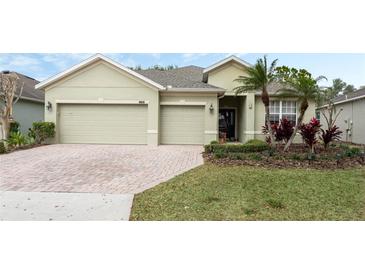 Charming single-story home featuring a well-maintained lawn, a brick driveway, and a spacious two-car garage at 3289 Saloman Ln, Clermont, FL 34711