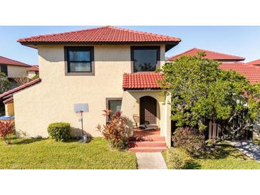 Charming two-story home with a red tile roof, well-maintained lawn, and inviting entryway at 549 Hunter Cir, Kissimmee, FL 34758