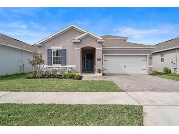 Charming single-story home with a well-maintained lawn, stone accents, and a two-car garage at 704 Hyperion Dr, Debary, FL 32713