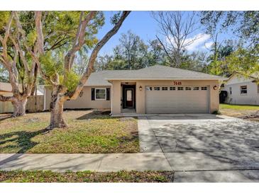 Charming single-story home featuring a two-car garage and well-maintained lawn at 7448 Grand Ct, Winter Park, FL 32792