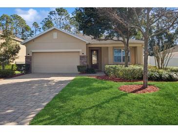 Charming single-story home with well-manicured lawn, brick driveway, and an attached two-car garage at 981 Galway Blvd, Apopka, FL 32703