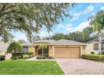 Charming single-story home with a manicured lawn, mature trees, and a two-car garage at 1195 Legendary, Clermont, FL 34711