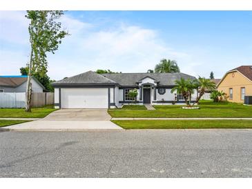 Charming single-story home with a well-manicured lawn and a two-car garage at 14923 Day Lily Ct, Orlando, FL 32824