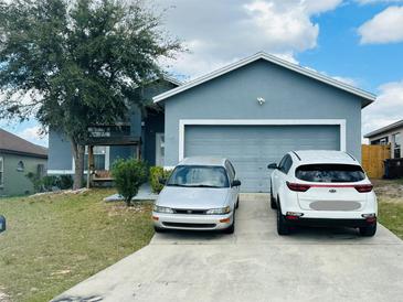 Charming two-story home with a two-car garage and a well-maintained front yard and driveway at 233 Ashley Loop, Davenport, FL 33837