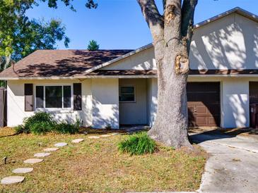 Charming single-story home featuring a well-maintained lawn, stone path, and attached garage at 2600 Musselwhite Ave, Orlando, FL 32804