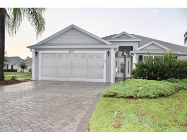 Charming single-story home featuring a two-car garage and a well-manicured front yard at 2628 Caribe Dr, The Villages, FL 32162